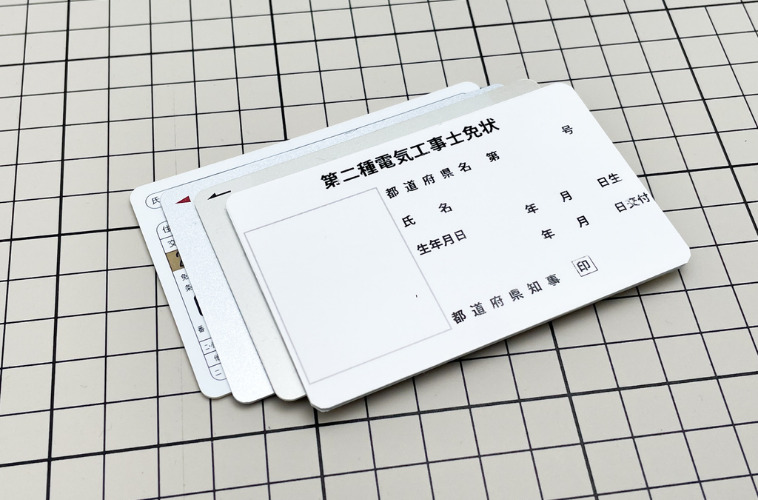 カードと第二種電気工事士免状プラスチックカードのサンプルを並べた写真
